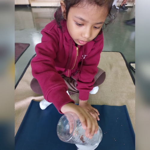 Pouring Ragi using Funnel Activity by Montessori Students